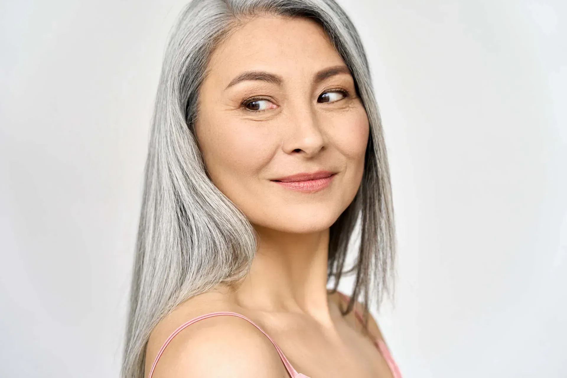 Smiling woman with long silver hair.