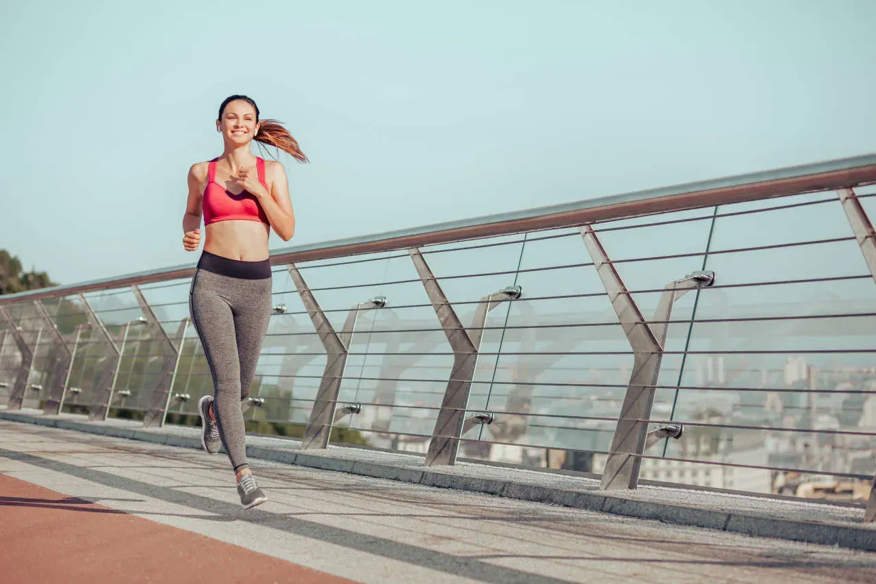 Smiling woman jogging on a sunny day.