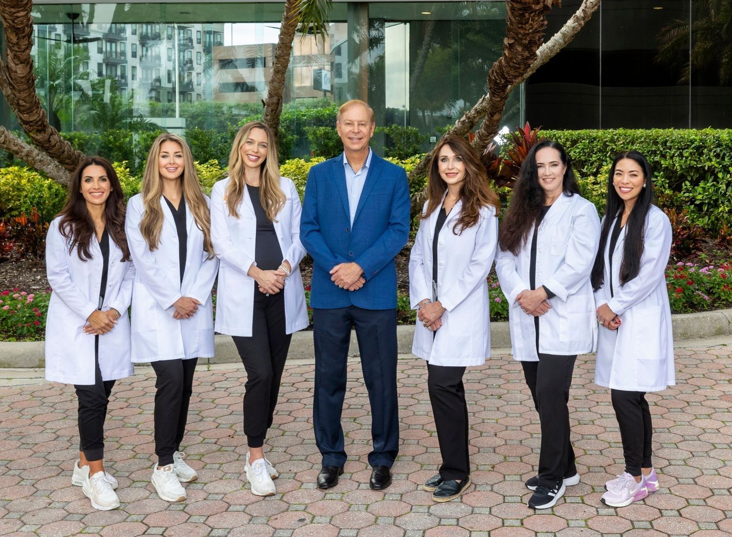 Team of medical professionals posing together outdoors.