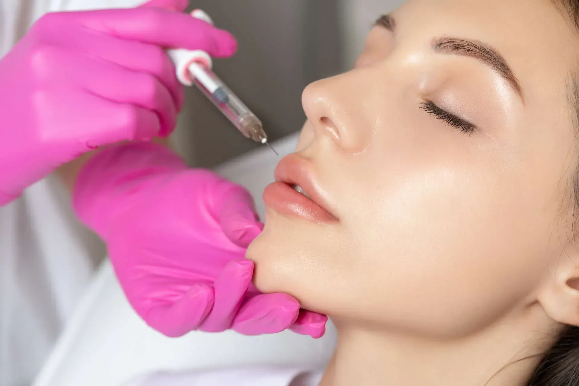 Lip injection procedure with medical professional's hands.