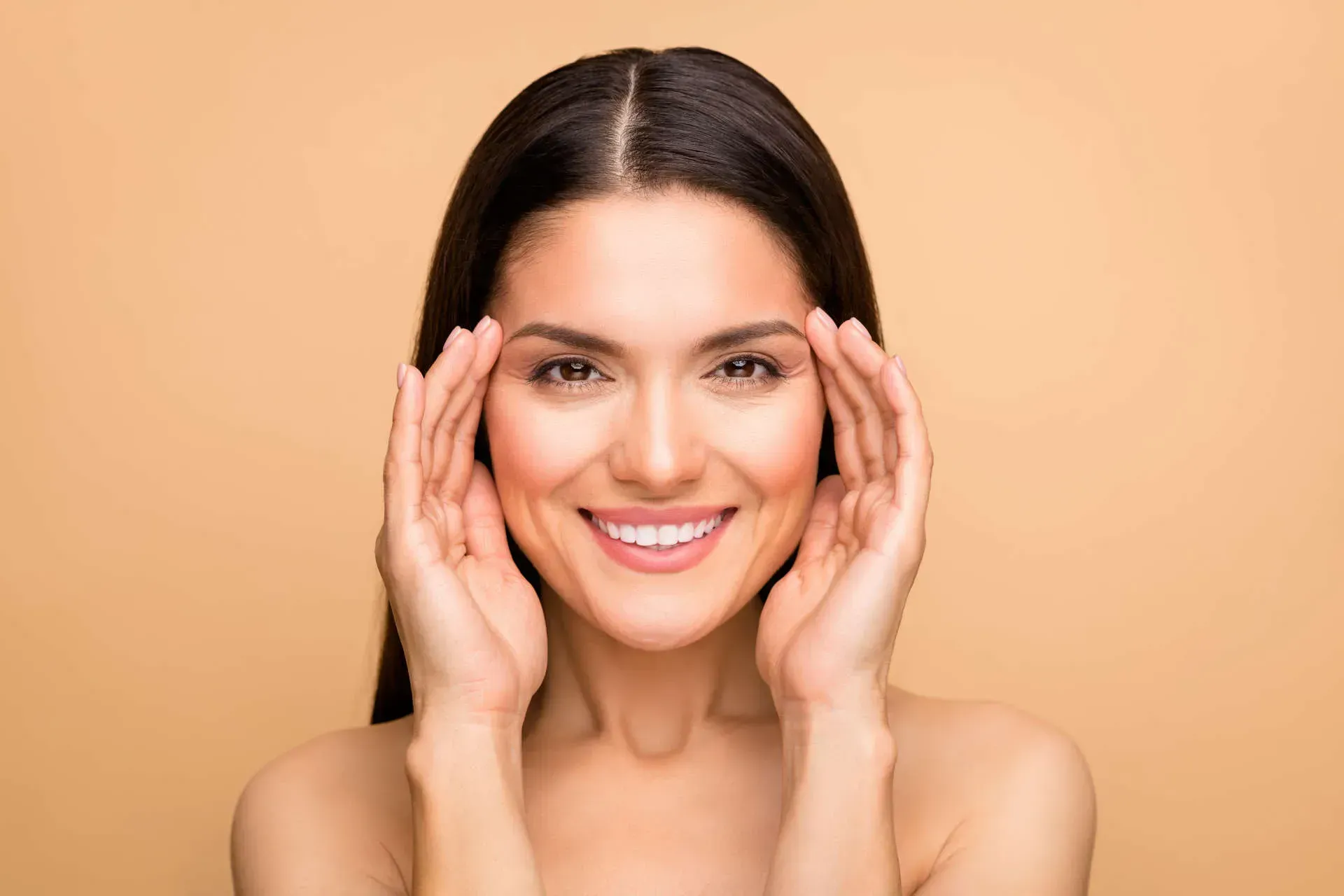 Smiling woman with hands on her face.